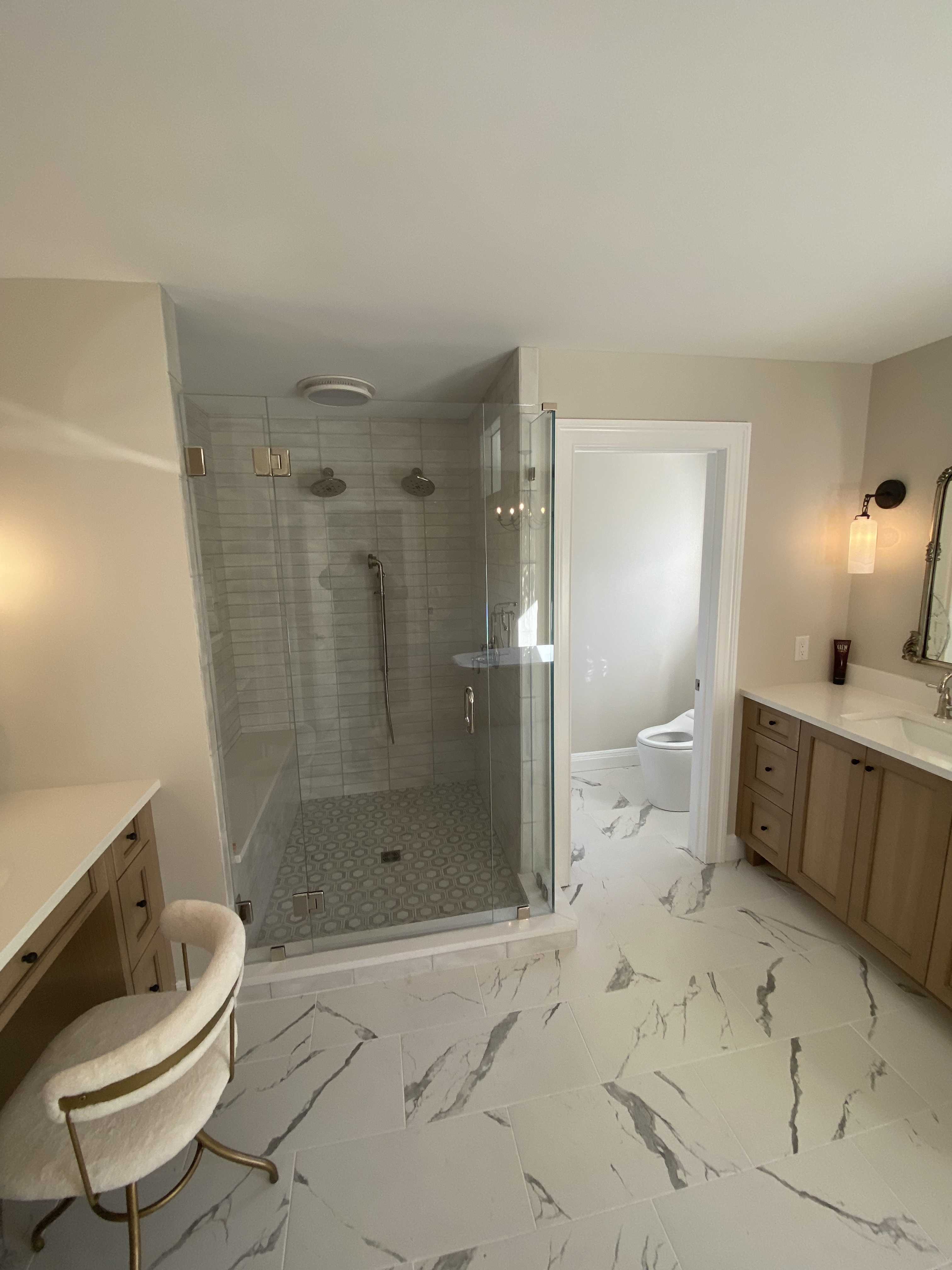 Rolling Hills bathroom — frameless glass shower with hexagon tile floor and dual rain heads by Luxe Built